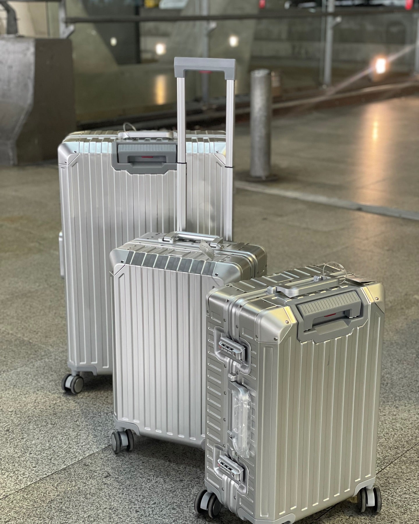 Silver aluminum suitcases with a durable hard shell, smooth spinner wheels, and telescopic handles, perfect for secure and stylish travel.